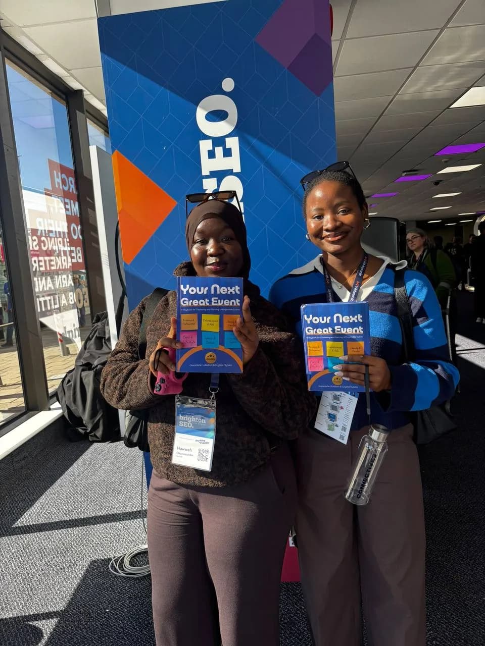Two people holding Your Next Great Event at an event