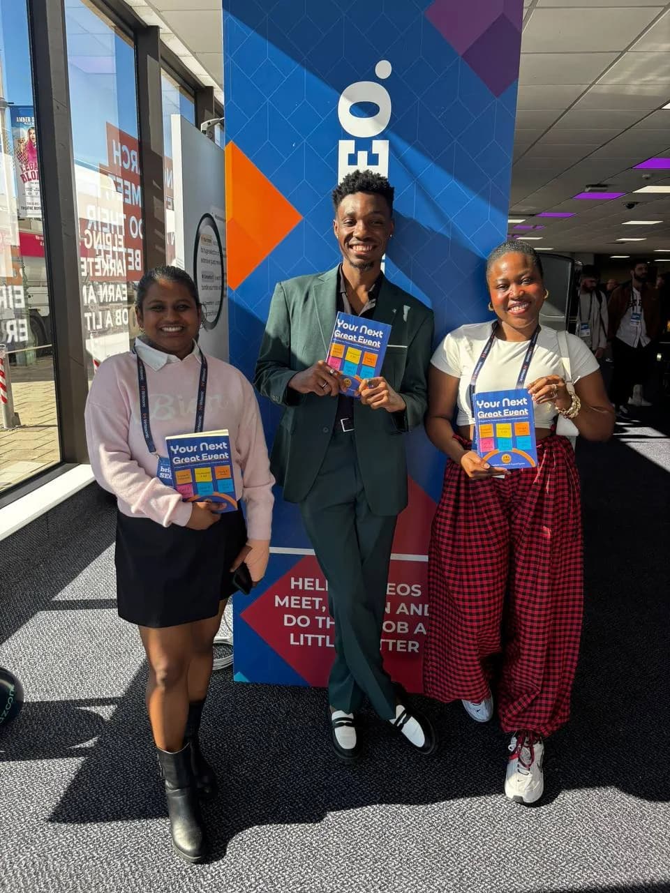 Three attendees holding copies of Your Next Great Event