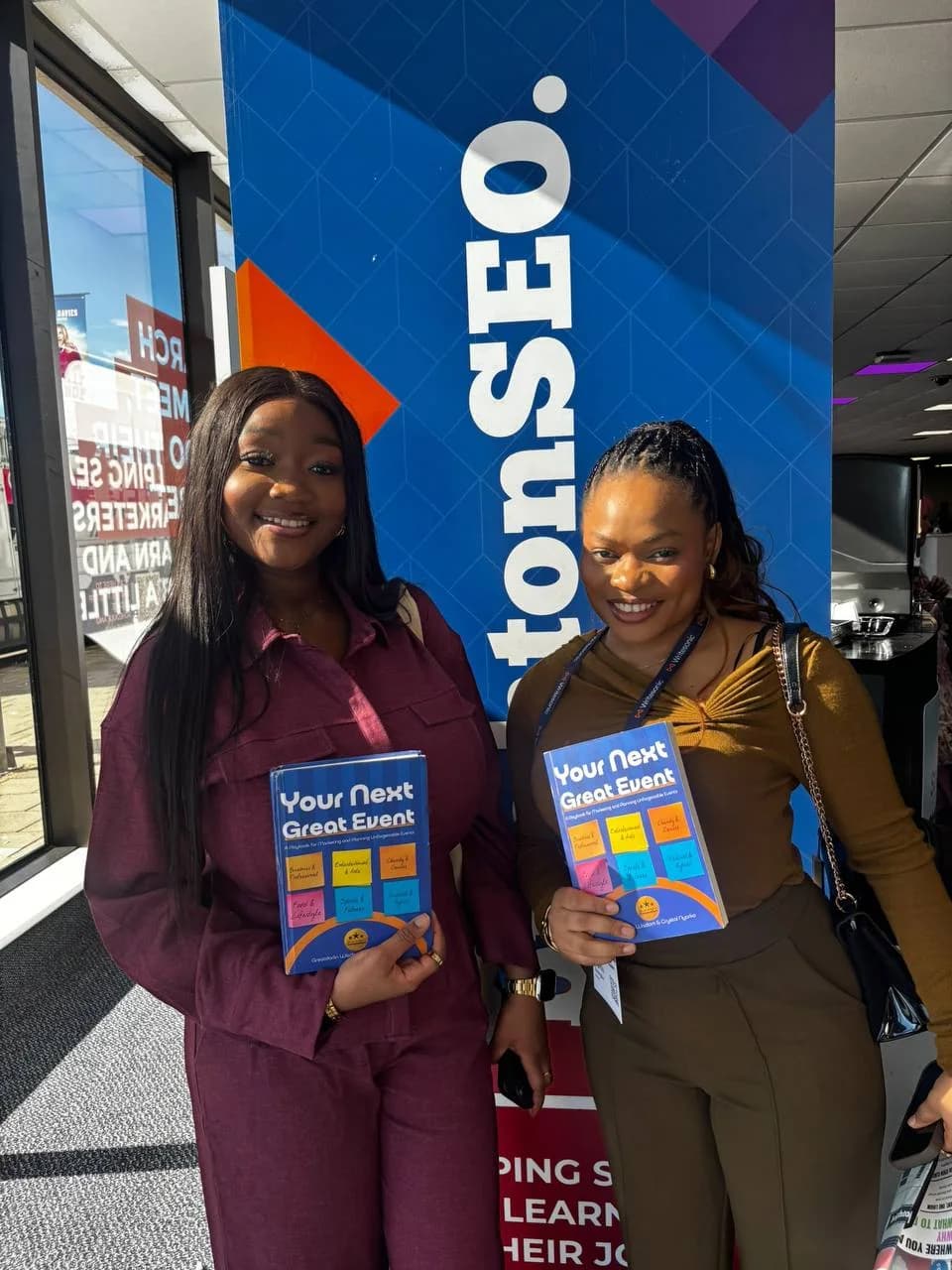 Two attendees with their copies of Your Next Great Event